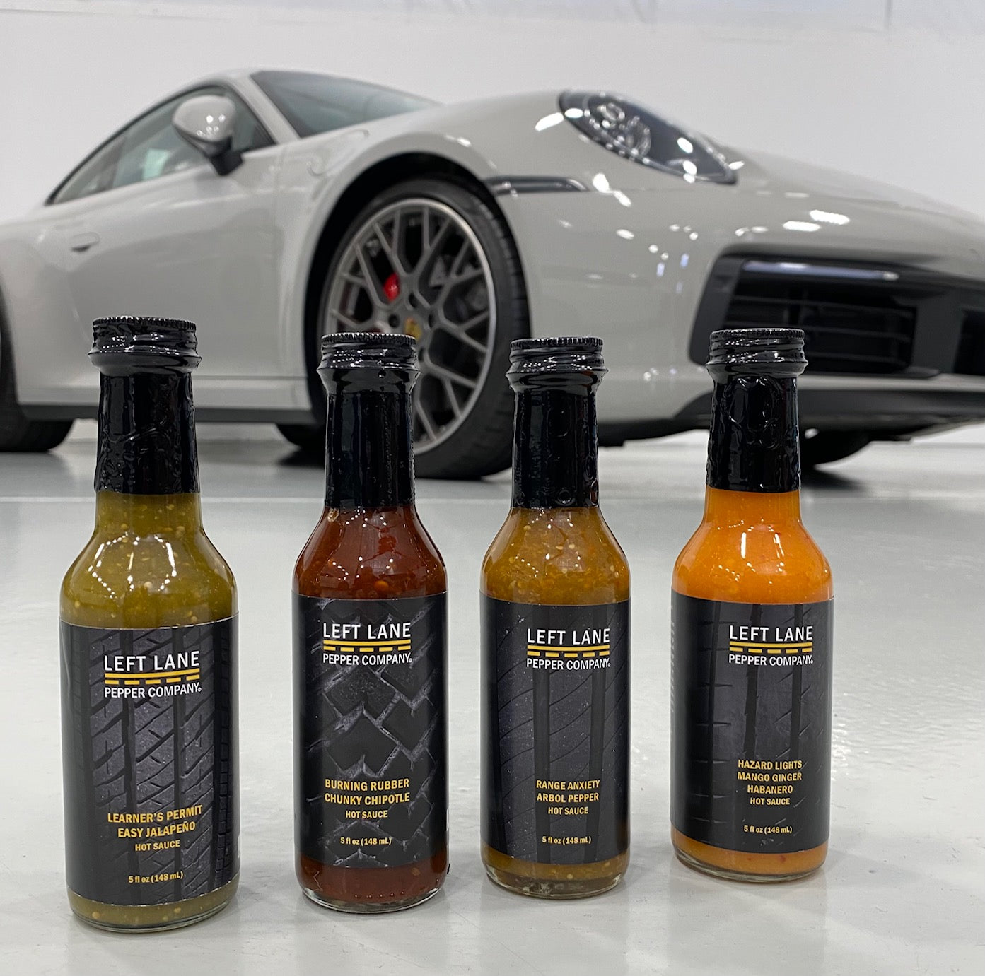 left lane pepper company hot sauces in front of sports car